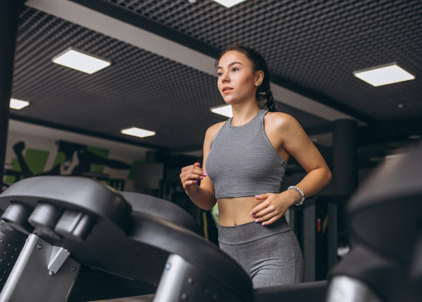 Девушка занимается на велотренажере